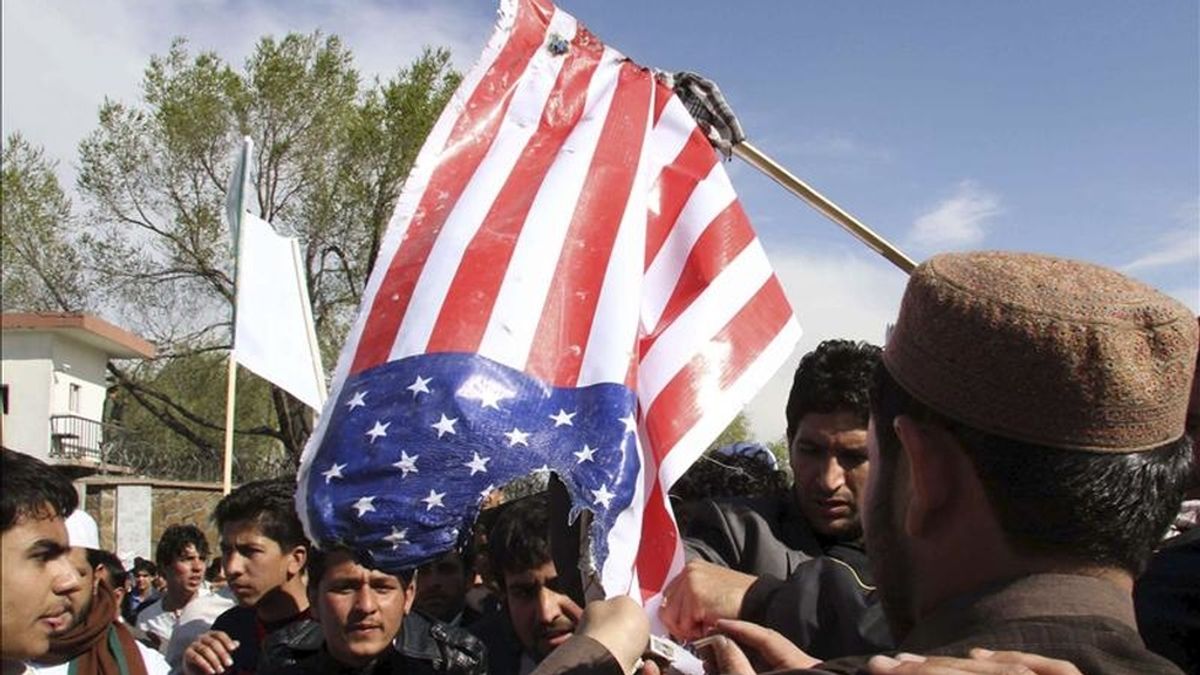 Ciudadanos afganos queman ayer una bandera de EEUU durante una protesta en contra de la quema del Corán en Kabul (Afganistán). EFE
