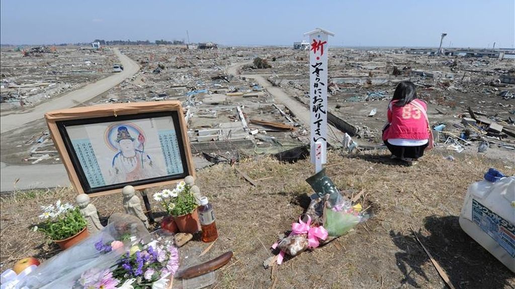 Residentes locales oran en un monumento budista hoy, 10 de abril de 2011, junto a los escombros de la devastación producida por el tsunami que destruyó a Natori (Japón). Japón vota en elecciones locales condicionadas por el devastador terremoto. EFE