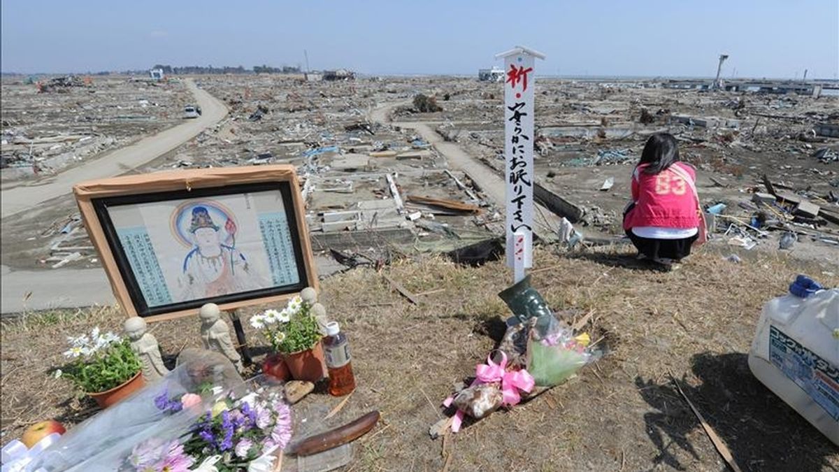 Residentes locales oran en un monumento budista hoy, 10 de abril de 2011, junto a los escombros de la devastación producida por el tsunami que destruyó a Natori (Japón). Japón vota en elecciones locales condicionadas por el devastador terremoto. EFE