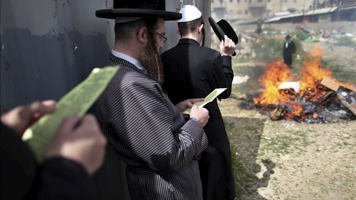 Judíos ortodoxos rezan mientras queman pan de molde en el barrio Mea Shearim de Jerusalén, Israel, antes del comienzo de la Pascua Judía al anochecer. EFE