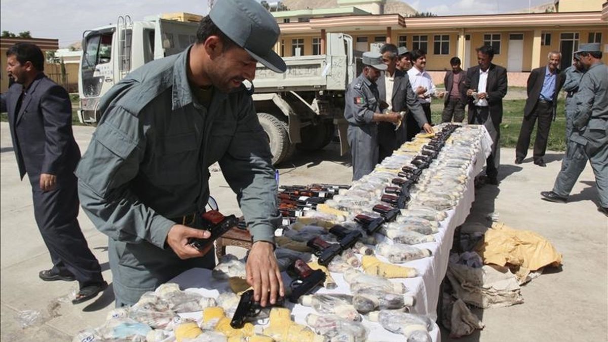 Unos oficiales de los cuerpos de seguridad afganos muestran armas y munición hallados en un vehículo en Pol-e-Khumri, en la provincia de Baghlan, Afganistán, ayer lunes 9 de mayo. EFE