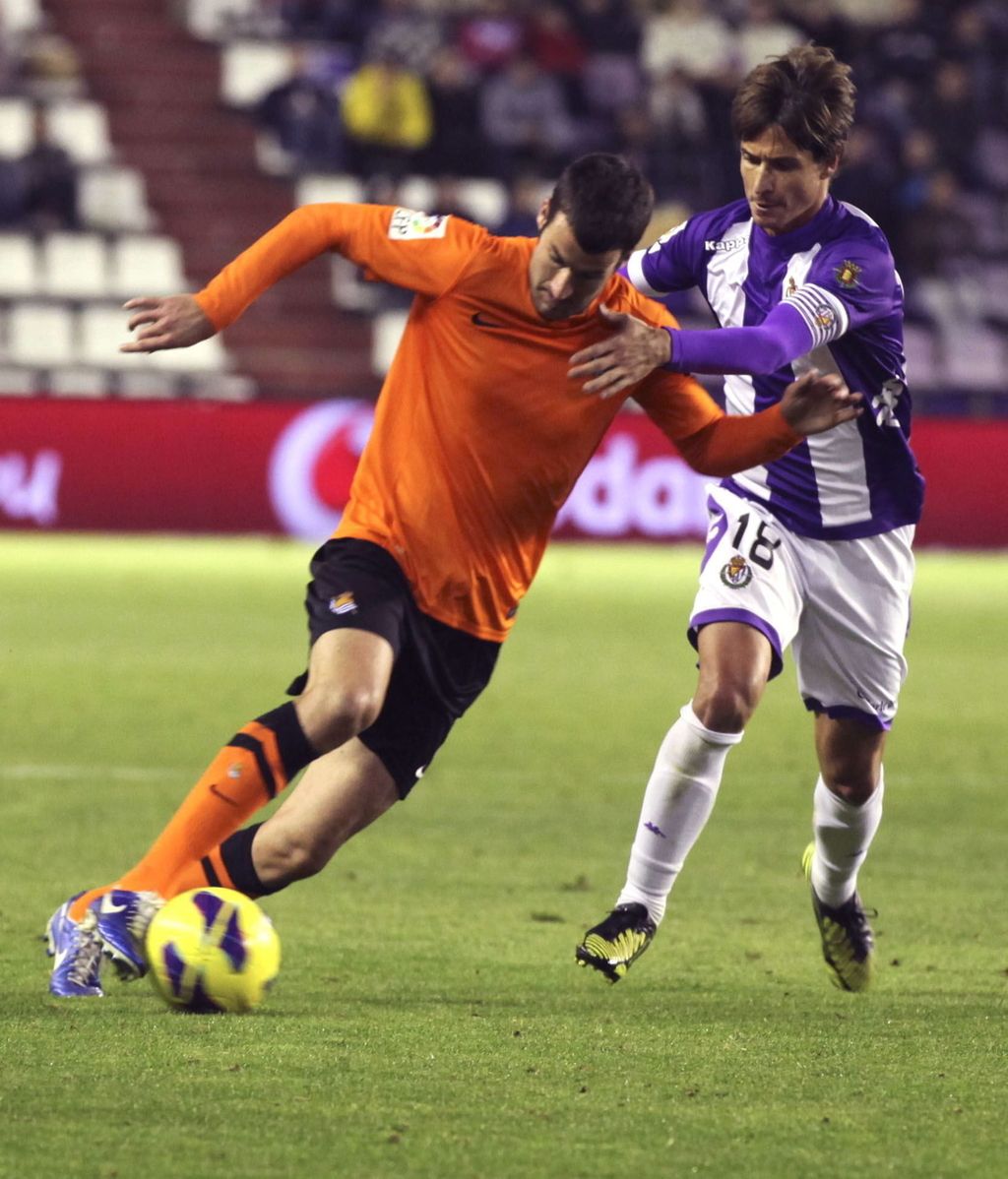 El delantero de la Real Sociedad, Imanol Agirretxe (i), se lleva el balón ante el acoso del defensor del Real Valladolid, Álvaro Rubio