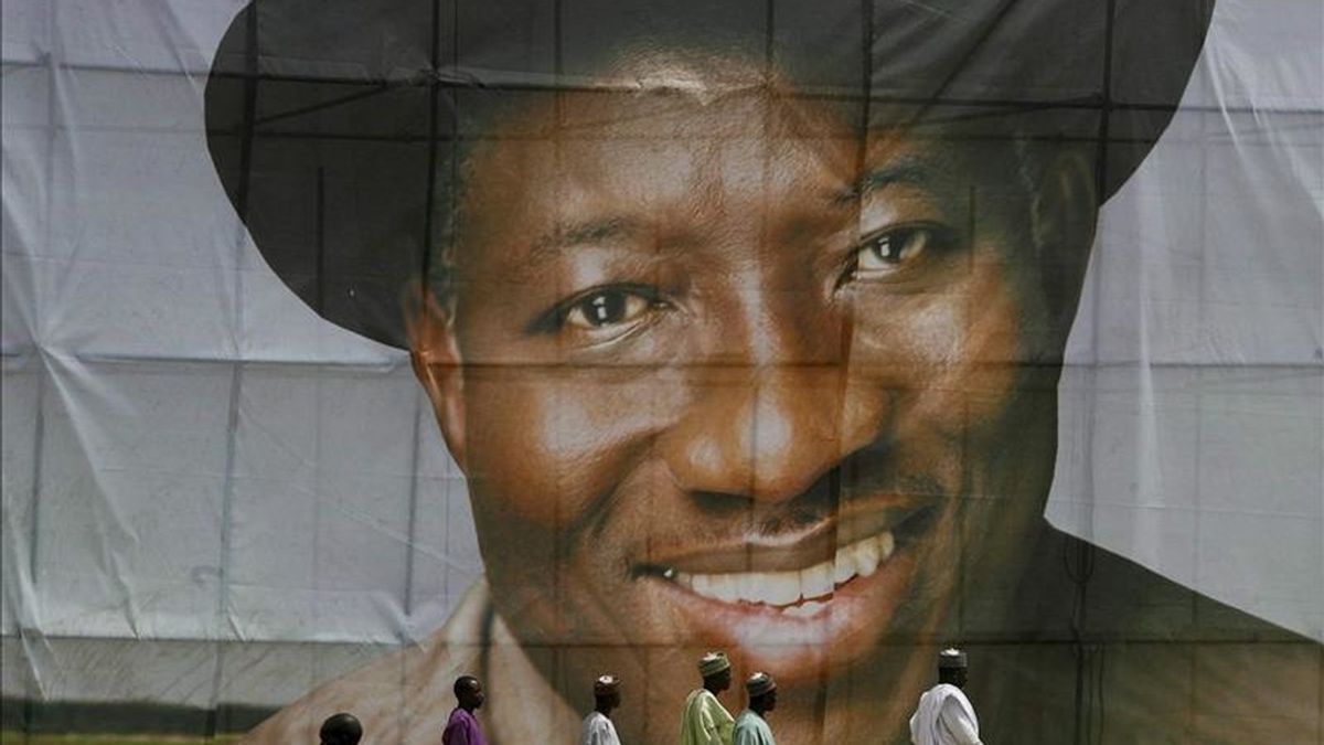 Imagen que muestra a hombres nigerianos que caminan al frente de una pancarta del actual presidente nigeriano, Goodluck Jonathan, durante su campaña electoral, en Kaduna, al noroeste de Nigeria. EFE