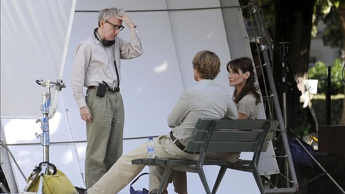 El director estadounidense Woody Allen (c) habla con la primera dama francesa Carla Bruni-Sarkozy (d) y el actor estadounidense Owen Wilson (2-d)  durante el rodaje de su película, "Media noche en París". EFE/Archivo