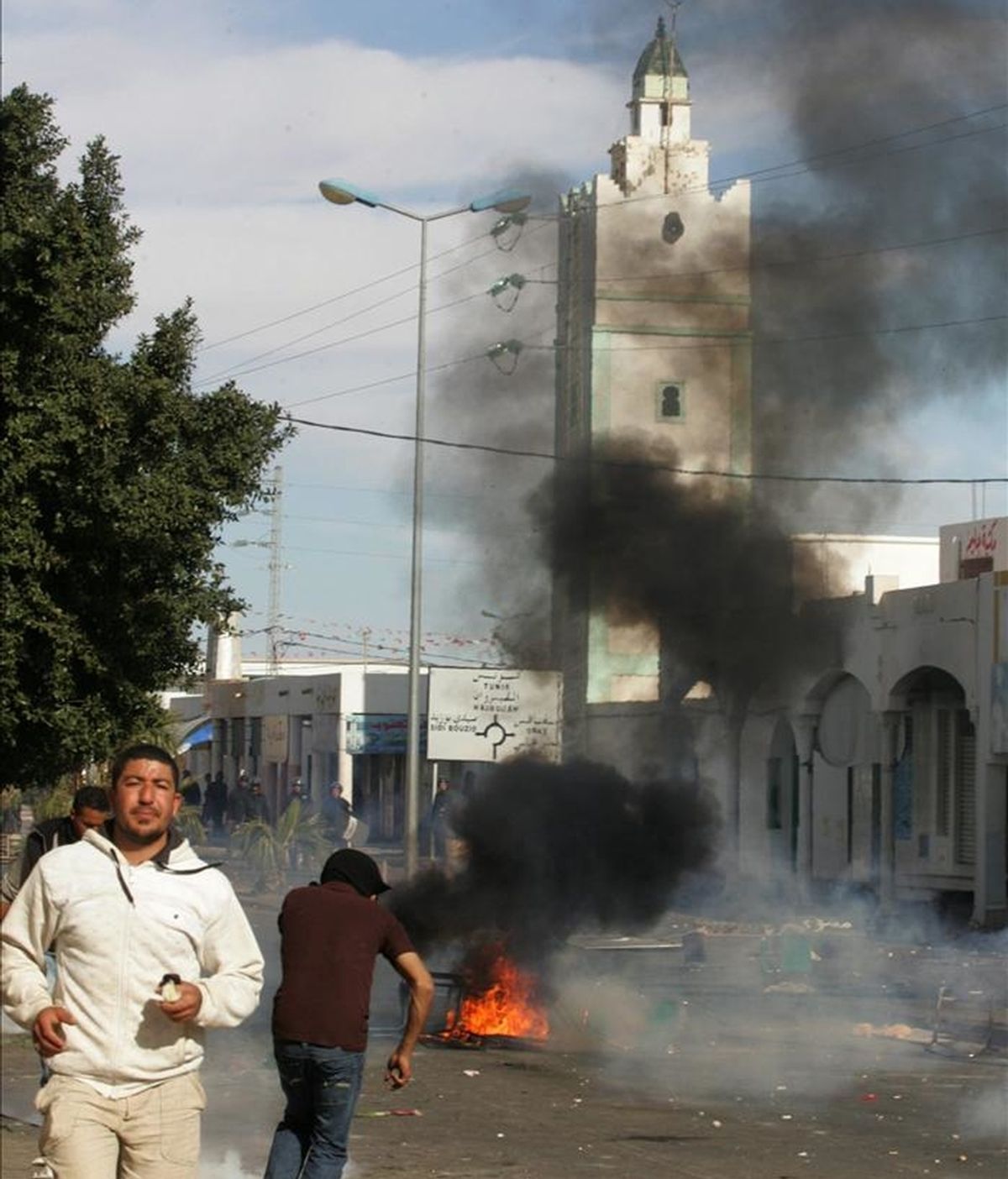 Fotografía de archivo del 10 de enero de 2011 de manifestantes en una barricada incendiada en Regueb (Túnez). EFE/Archivo
