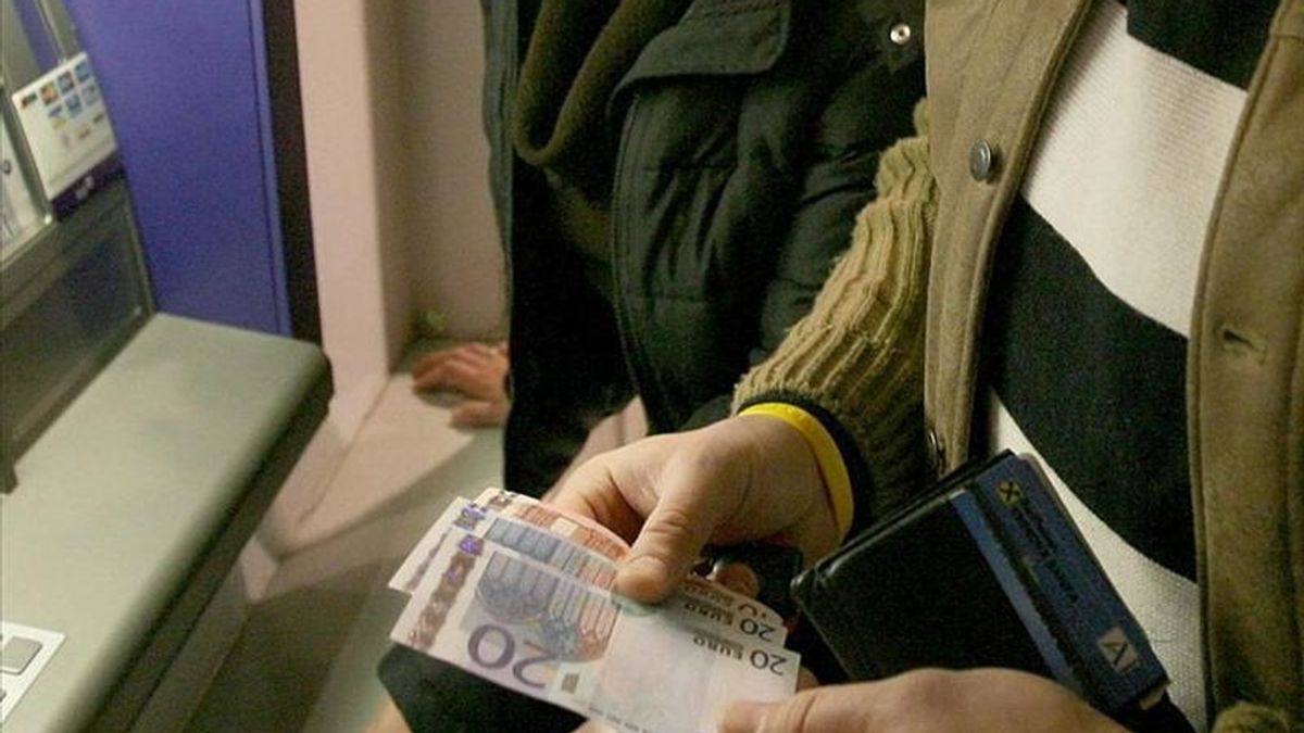 Un hombre observa billetes de euro en un cajero. EFE/Archivo
