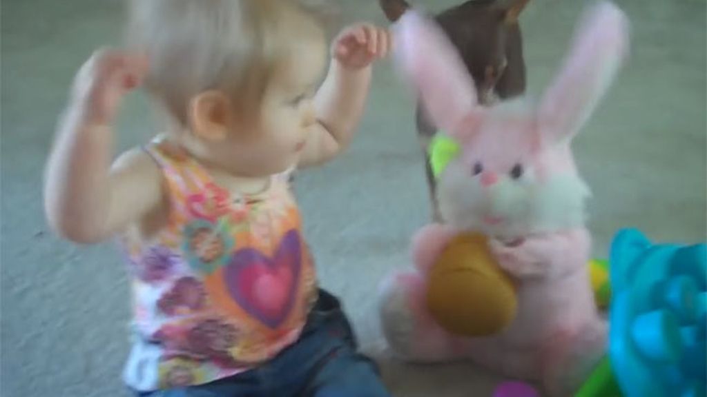 El gracioso baile de una bebé con un conejito de juguete