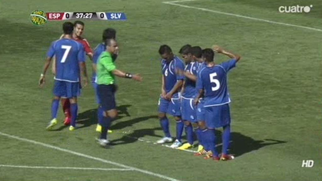 Los jugadores de El Salvador intentan borrar la línea que el árbitro pinta con espray