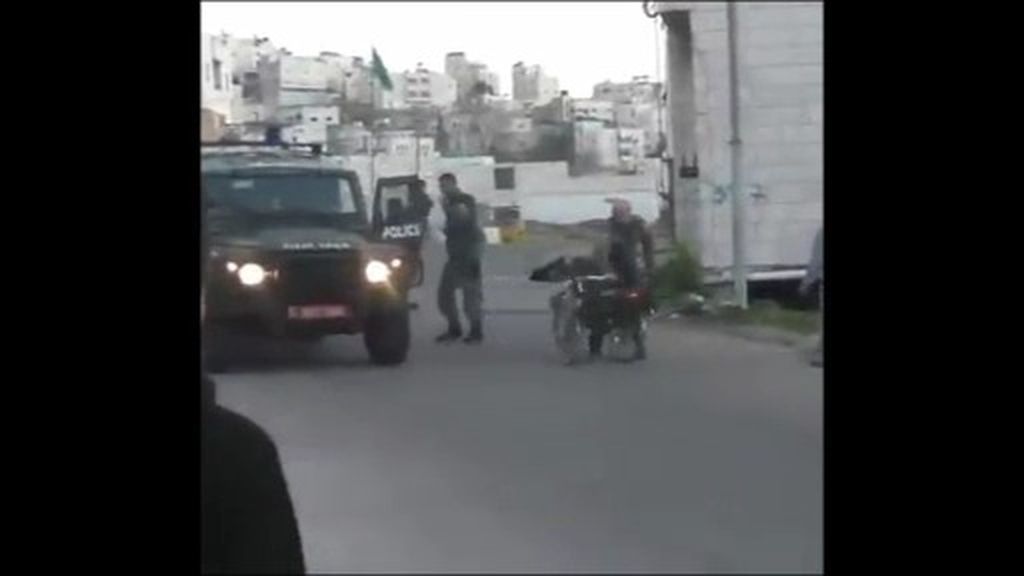 Un guardia israelí empuja a un palestino discapacitado