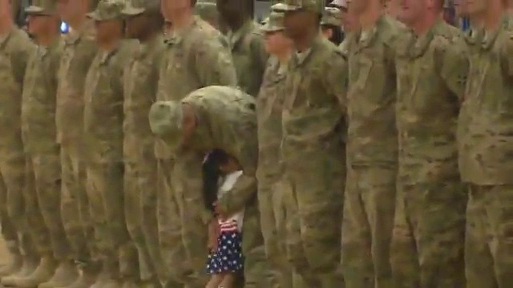 Una niña corre a abrazar a su padre en plena ceremonia militar de bienvenida a casa