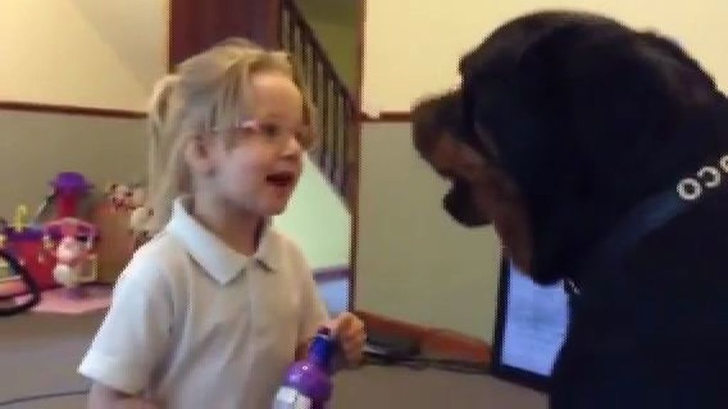 Un Rottweiller y una niña cantan juntos canciones de cuna