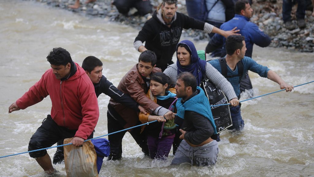 Multitud de refugiados desafían a la fuerza de un río en su intento de huir de Idomeni