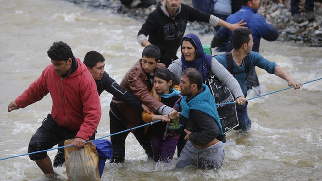Multitud de refugiados desafían a la fuerza de un río en su intento de huir de Idomeni