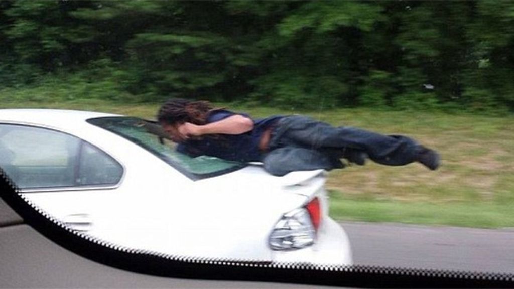Un hombre circula varios metros encaramado en el parabrisas de un coche