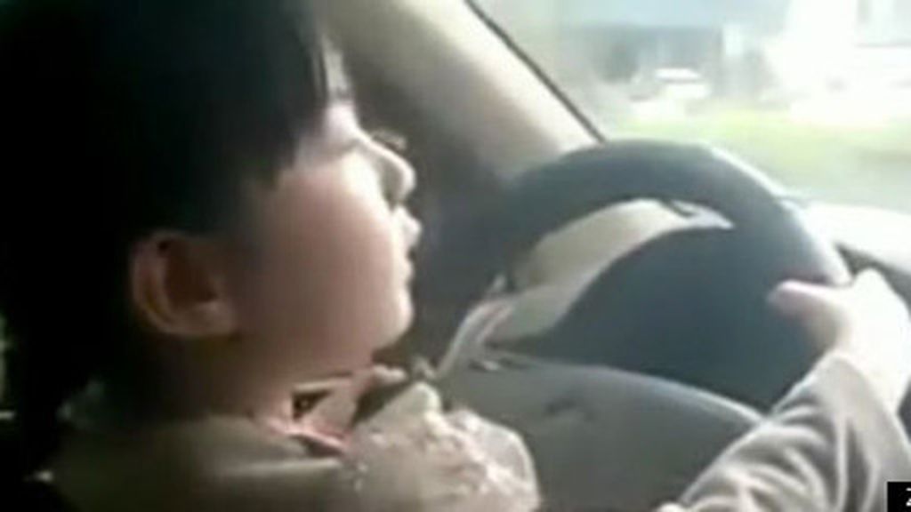 Una niña de cuatro años conduce un coche por una avenida en China