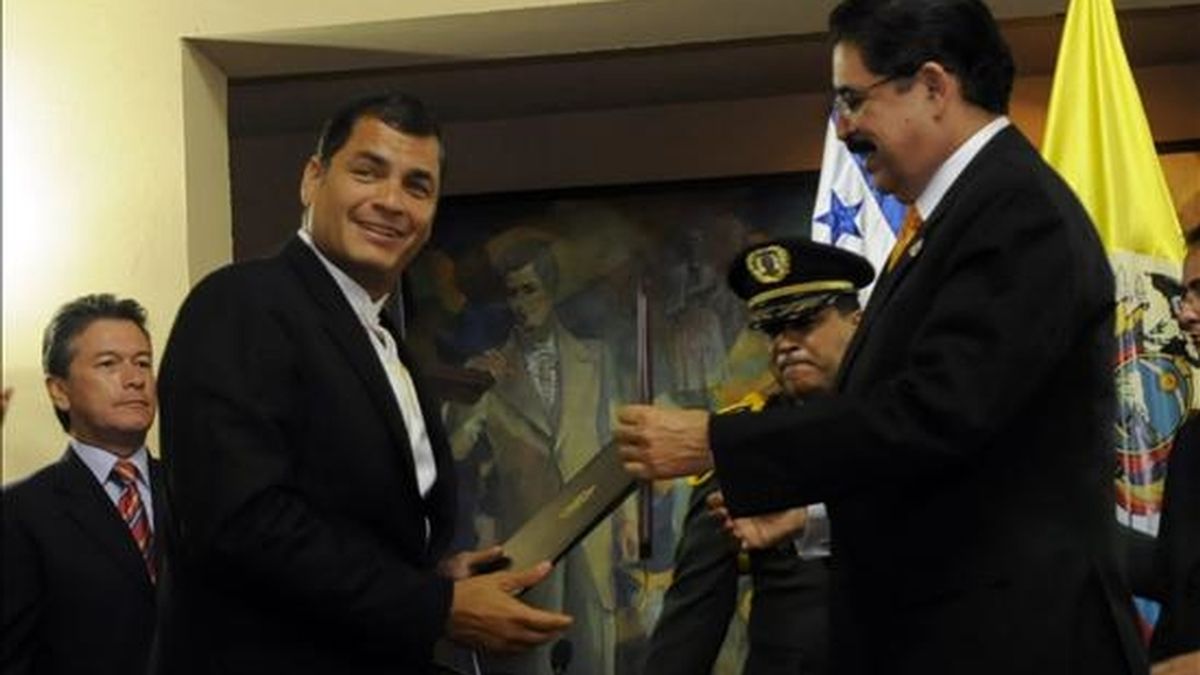 El presidente de Ecuador, Rafael Correa, recibe una condecoración de manos de su homólogo de Honduras, Manuel Zelaya, a su llegada a la casa presidencial en San Pedro Sula (Honduras) durante su visita oficial al país. EFE