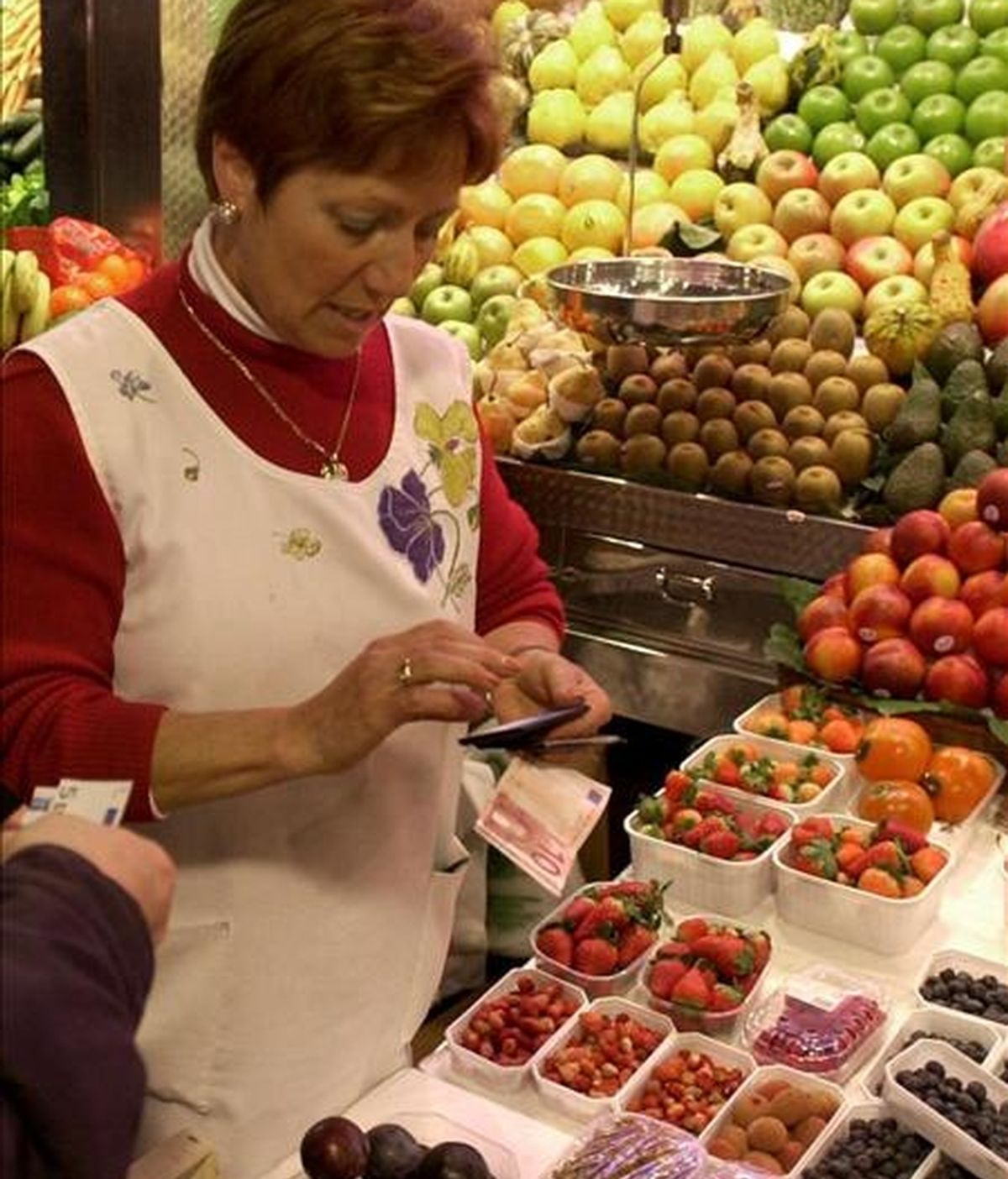 Una dependienta de un puesto de frutas de un mercado. EFE/Archivo