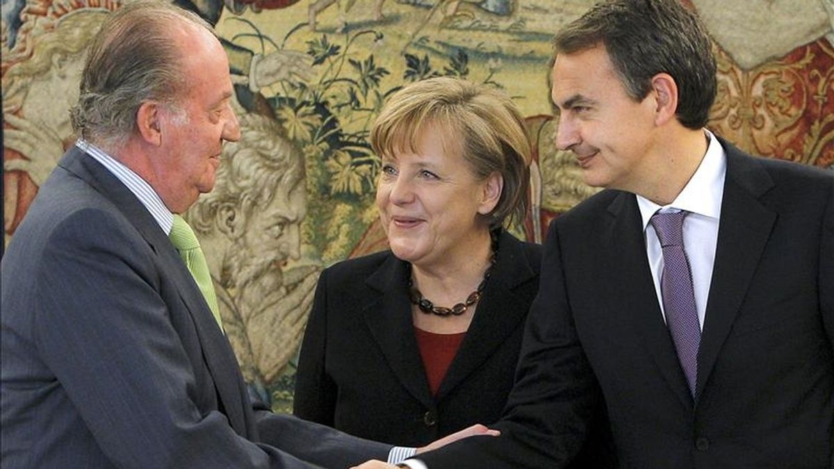 El rey Juan Carlos recibe el saludo del presidente del Gobierno, José Luis Rodríguez Zapatero (d), durante la recepción oficial a la canciller alemana, Angela Merkel (c), que tuvo lugar hoy en el Palacio de la Zarzuela, con motivo de la XXIII cumbre bilateral. EFE