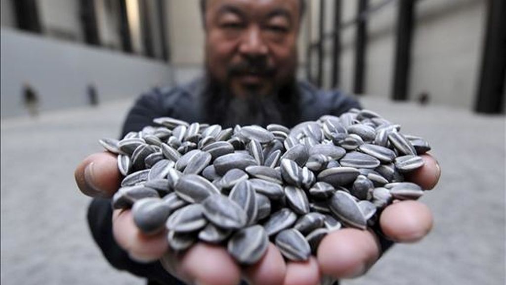 El renombrado artista chino Ai Weiwei sostiene un puñado de semillas de girasol de porcelana, durante la inauguración hoy de su exhibición 'Sunflower Seeds' en el Museo Tate Modern de Londres, Reino Unido. EFE El renombrado artista chino Ai Weiwei sostiene un puñado de semillas de girasol de porcelana, durante la inauguración hoy de su exhibición 'Sunflower Seeds' en el Museo Tate Modern de Londres, Reino Unido. EFE