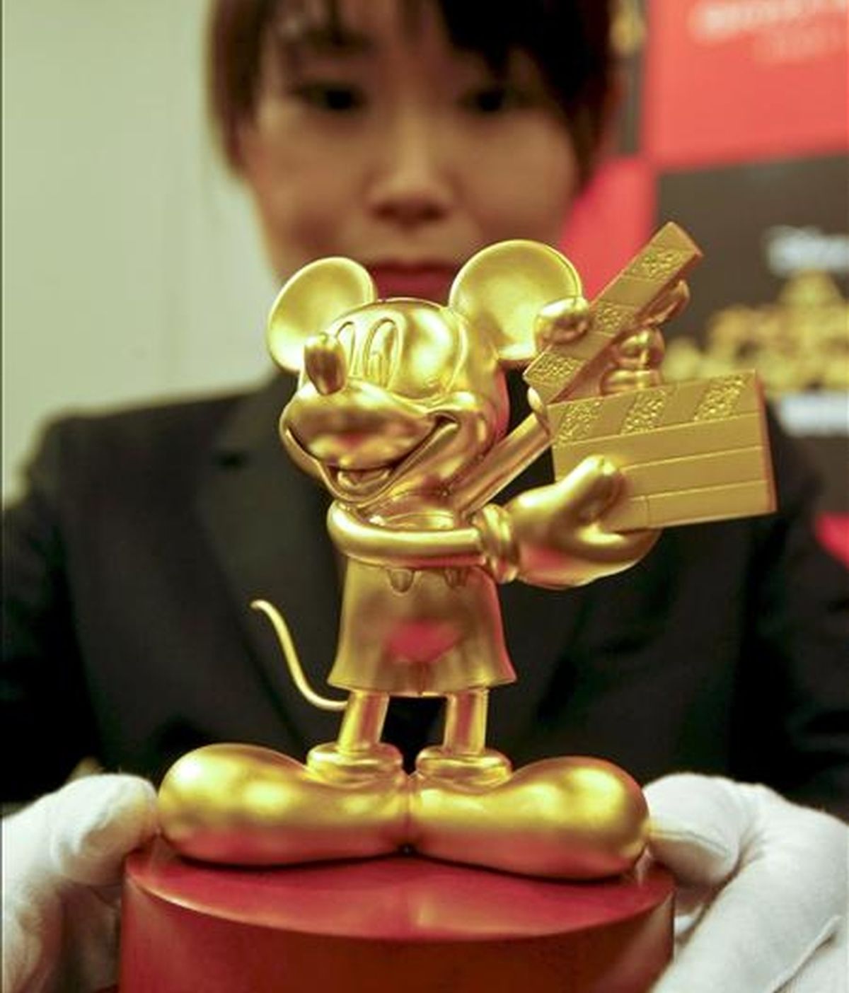 Una mujer coloca una figura de oro puro de Mickey Mouse en una rueda de prensa en Tokio (Japón). EFE/Archivo