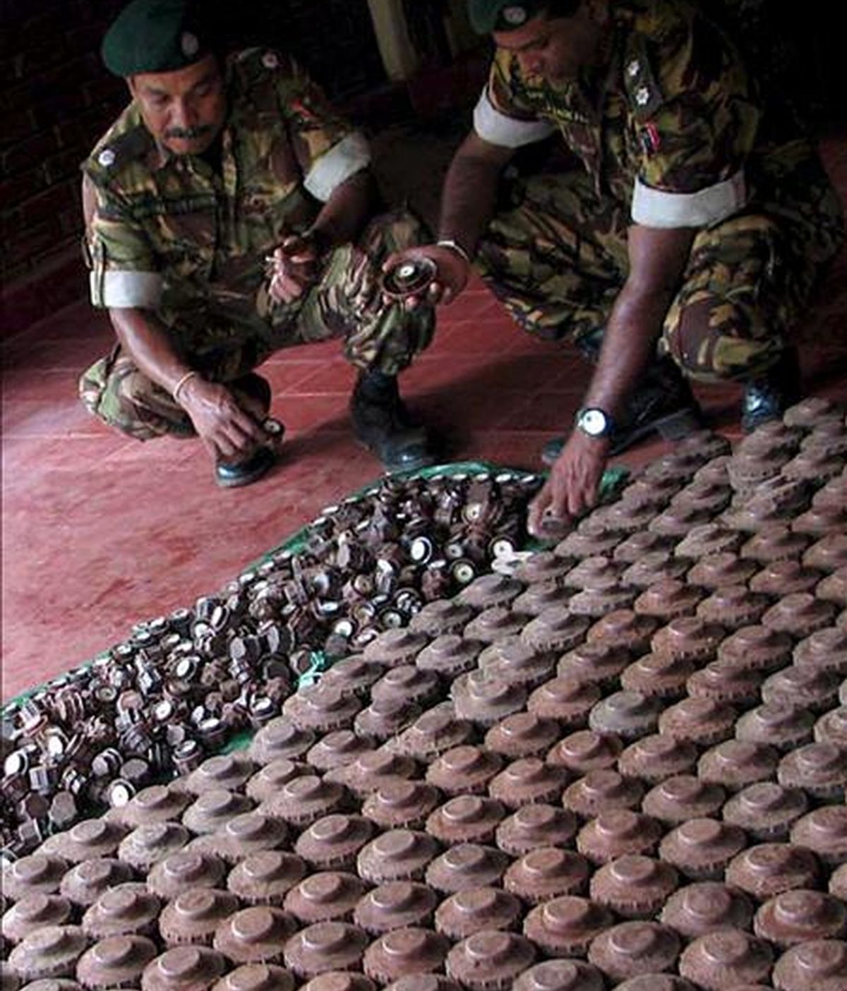 Miembros de una unidad especial de la policía realizan un recuento de minas antipersona y otros explosivos recuperados en áreas donde opera la guerrilla Tigres para la Liberación de la Patria Tamil (LTTE), el pasado 3 de abril. EFE/Archivo