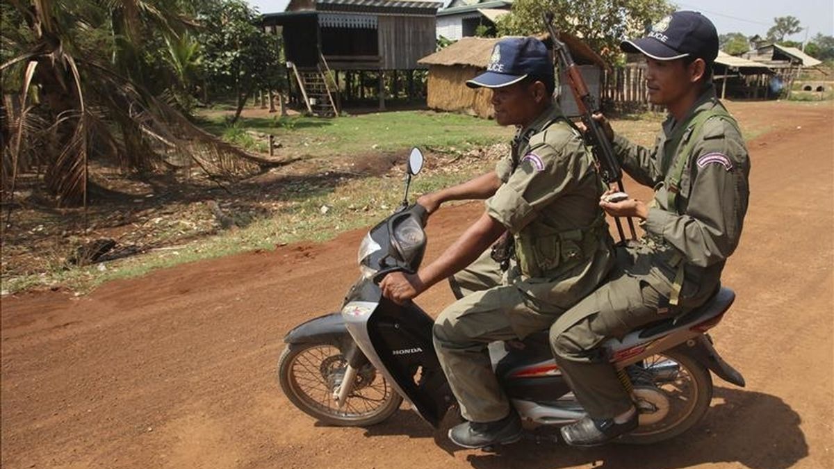 Dos policías camboyanos patrullan por una aldea cerca de los recientes combates que se producen en la zona fronteriza con tailandia que han causado la muerte de varios soldados de ambos países y decenas de miles de desplazados, en Oddar Meanchey, Camboya. EFE