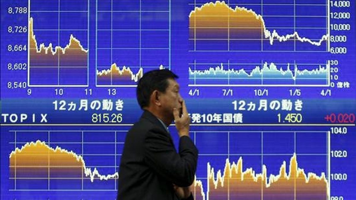 Un ejecutivo japonés camina frente a un tablero electrónico con valores de la Bolsa de Tokio (Japón). EFE/Archivo
