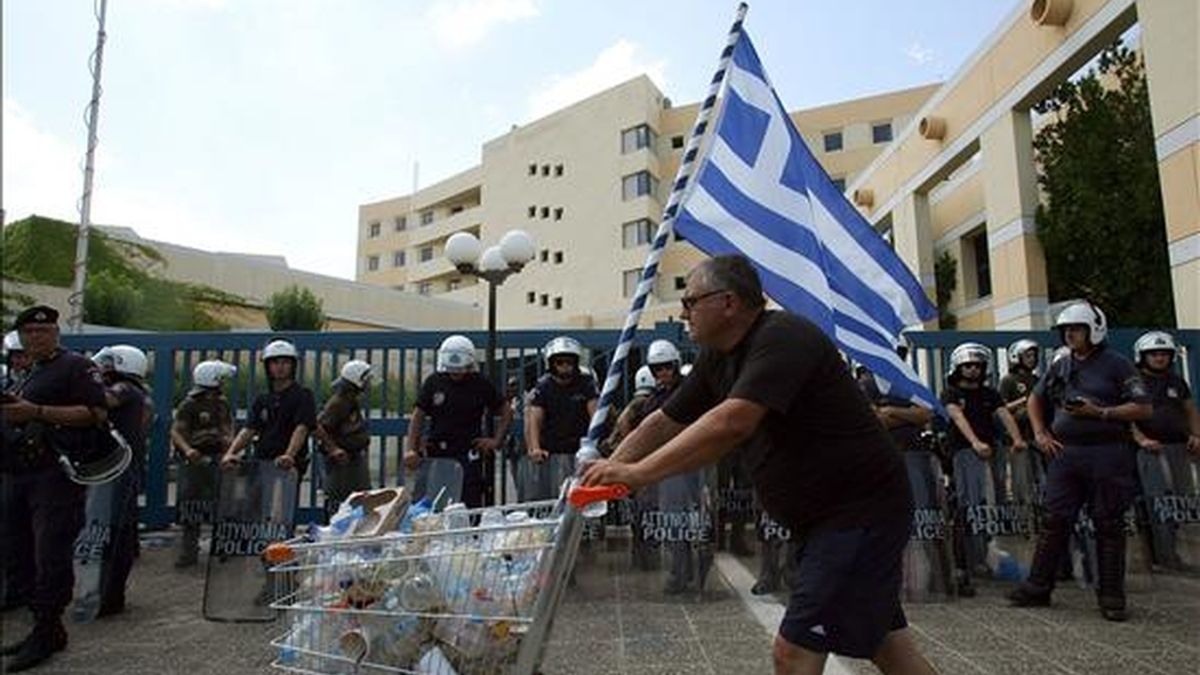 Un transportista empuja un carro de supermercado con basura durante un acto de protesta en el exterior del Ministerio de Transporte en Atenas, Grecia, ayer 29 de junio. EFE/Archivo