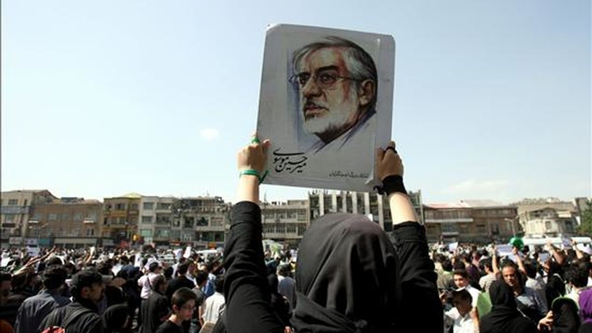 Una mujer iraní  muestra una imagen del líder de la oposición, Mir Husein Musavi, durante la jornada de duelo celebrada hoy. EFE/Bijan