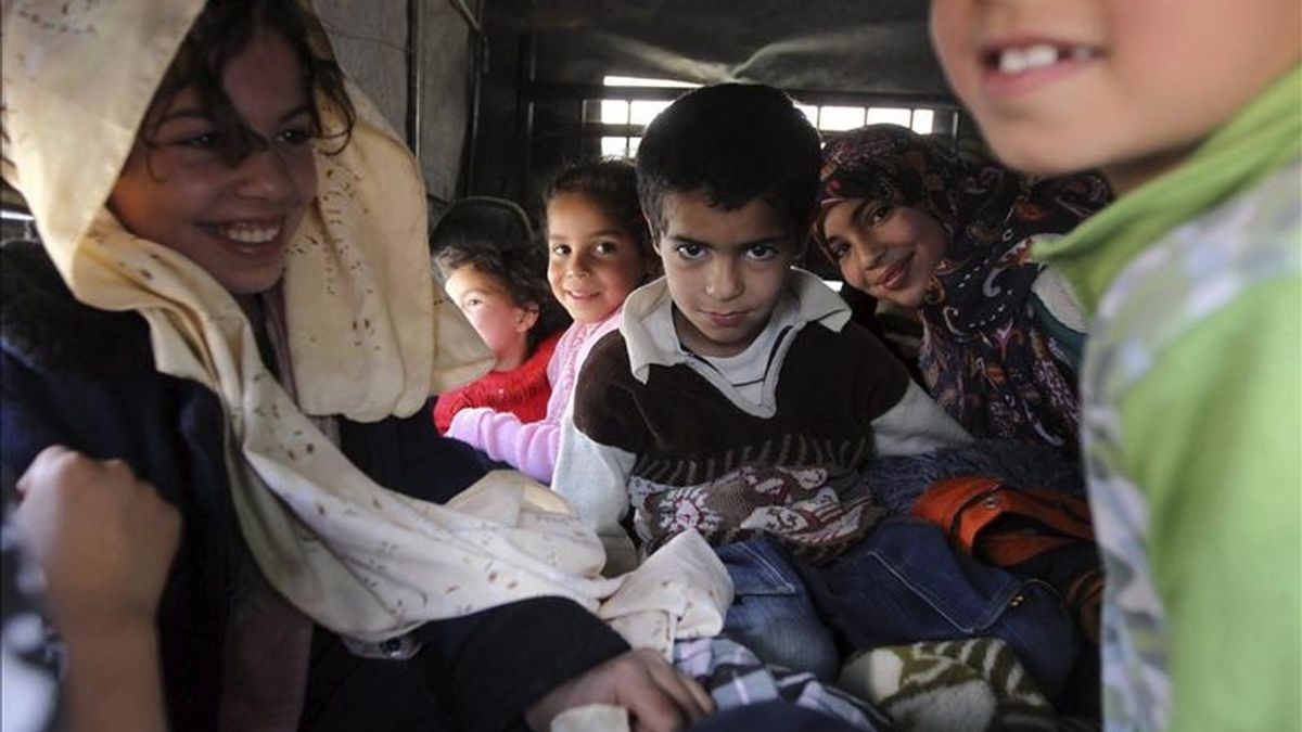 Una familia libia espera para cruzar la frontera hacia Túnez, en Wazin, sur de Libia. EFE