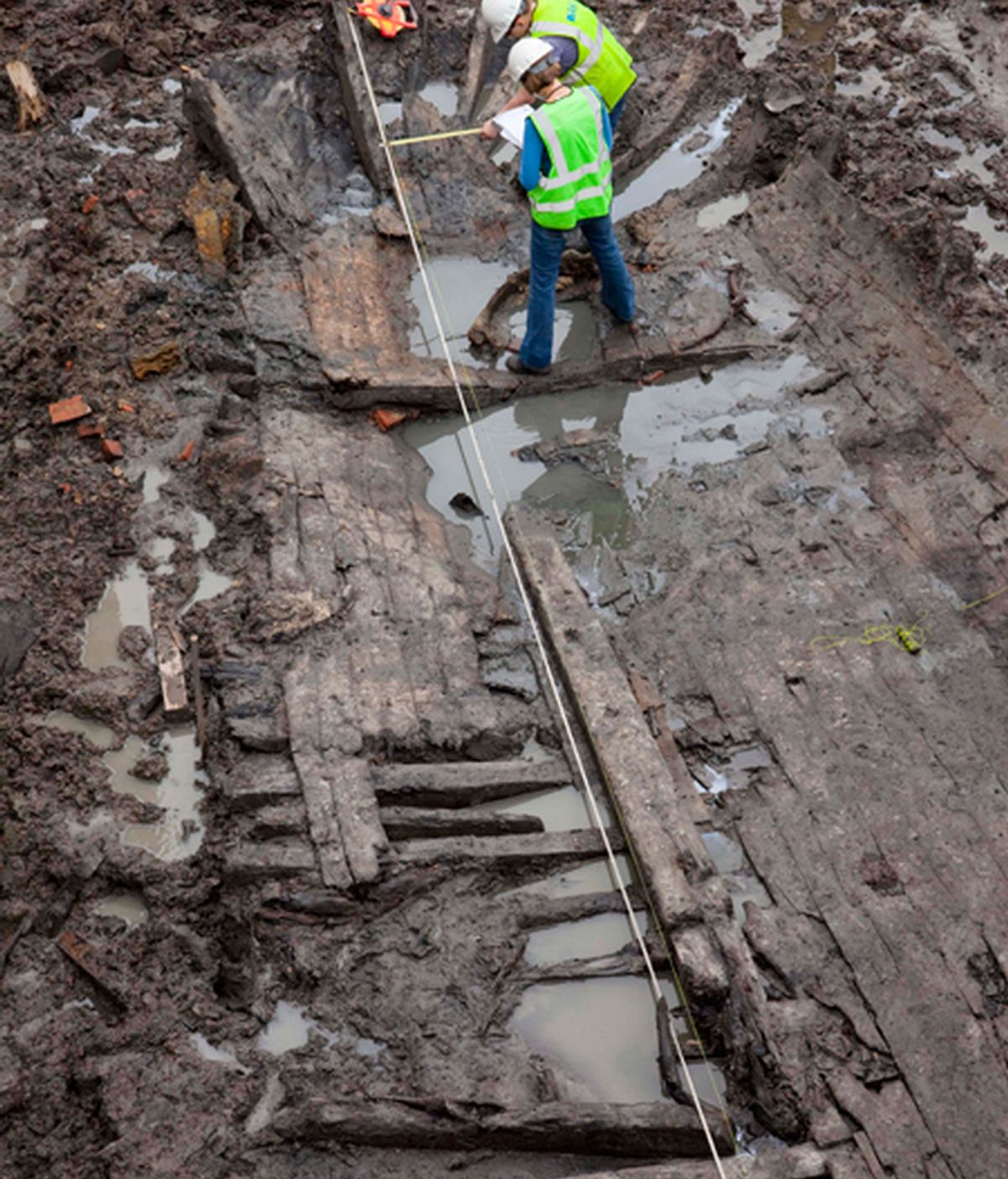 Dos arqueólogos toman medidas de los restos de la nave hallados en el World Trade Center. Foto: AP