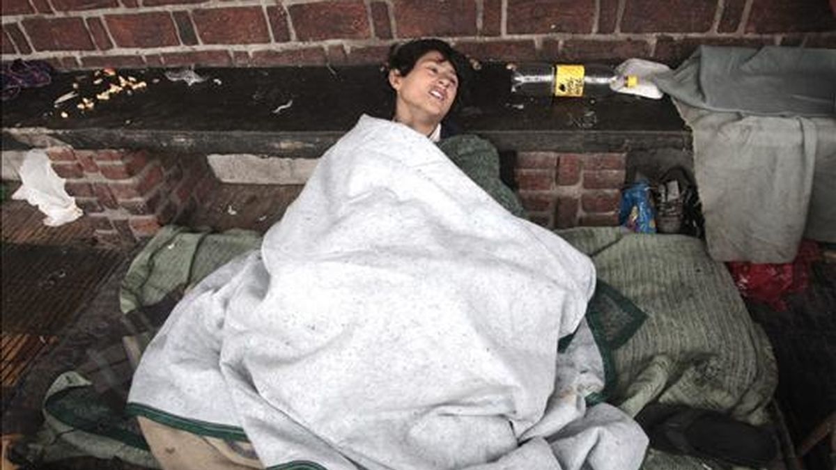 Azucena, una joven de 18 años, duerme en una acera de la entrada de la Villa 31 en Buenos Aires (Argentina). El número de muertos por la ola de frío que azota a la nación sudamericana llegó a once. EFE