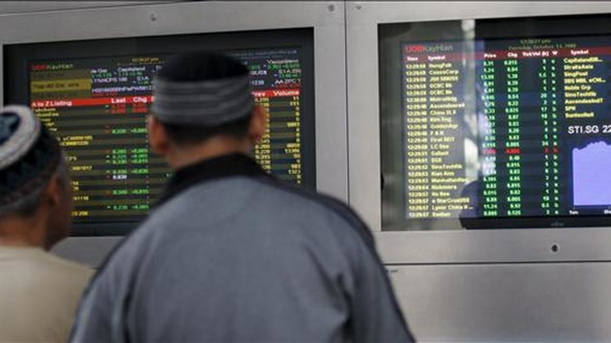 Dos inversores observan unos monitores en los que se muestran los valores de la Bolsa de Singapur. EFE/ARCHIVO