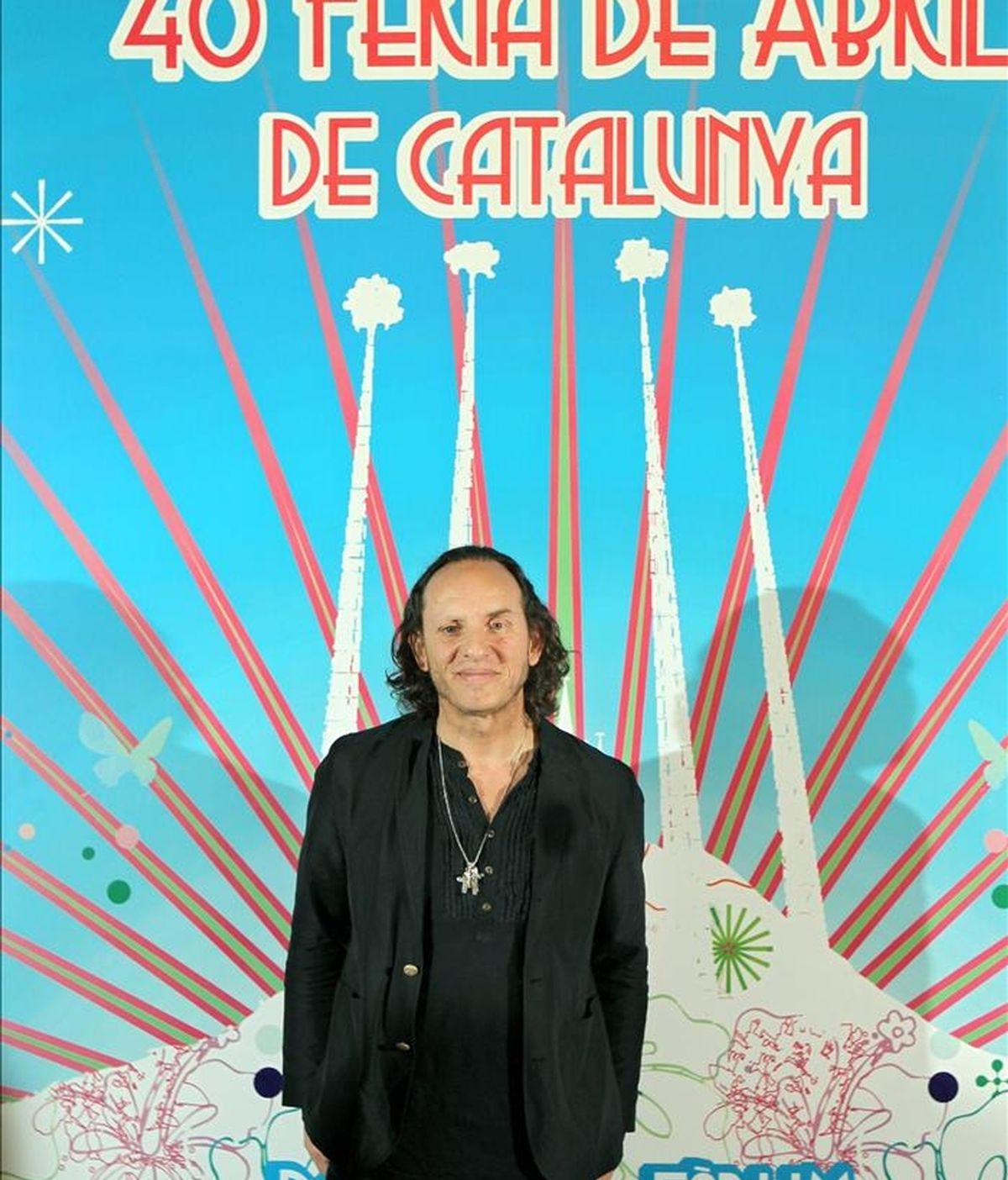 El diseñador de moda, Custo Dalmau, posa ante el cartel que ha diseñado para la Feria de Abril de Cataluña de este año, que tendrá lugar del 29 de abril al 8 de mayo en la explanada del Forum de Barcelona. EFE