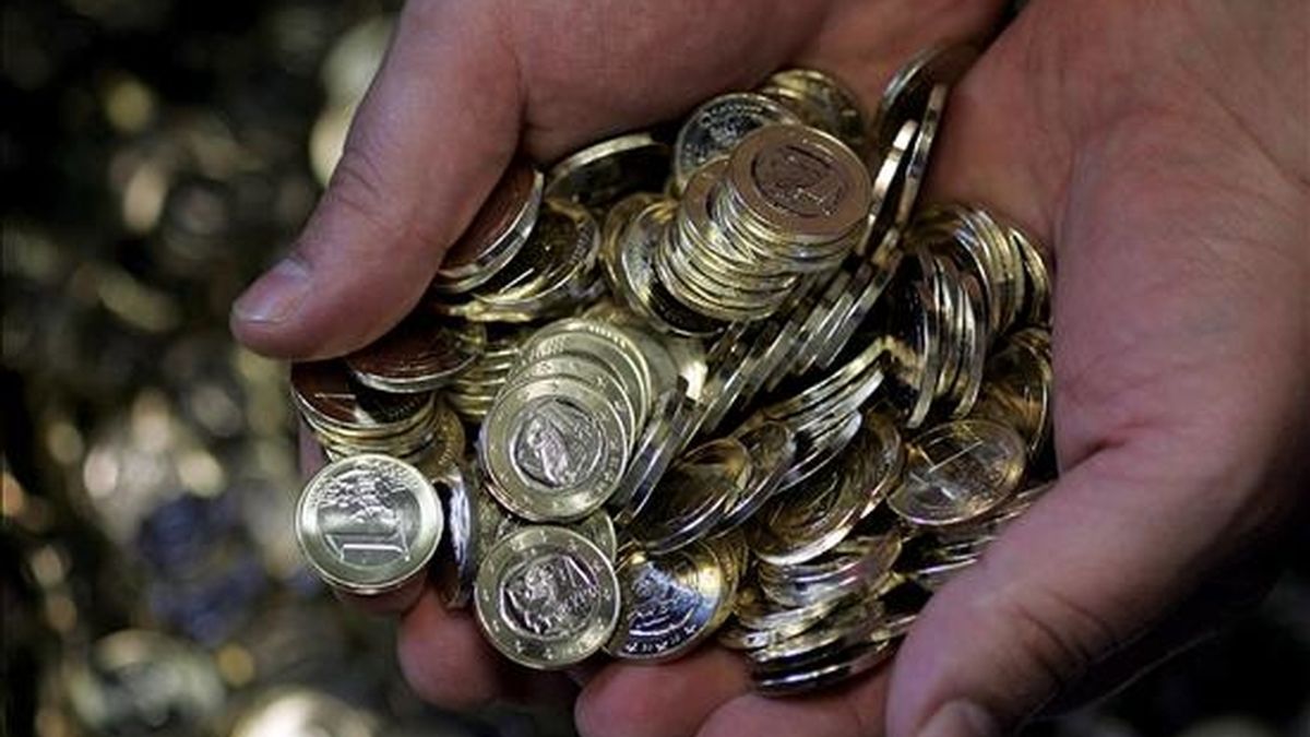 Un empleado de la Casa de la Moneda sostiene monedas de un euro en Atenas, Grecia. EFE/Archivo