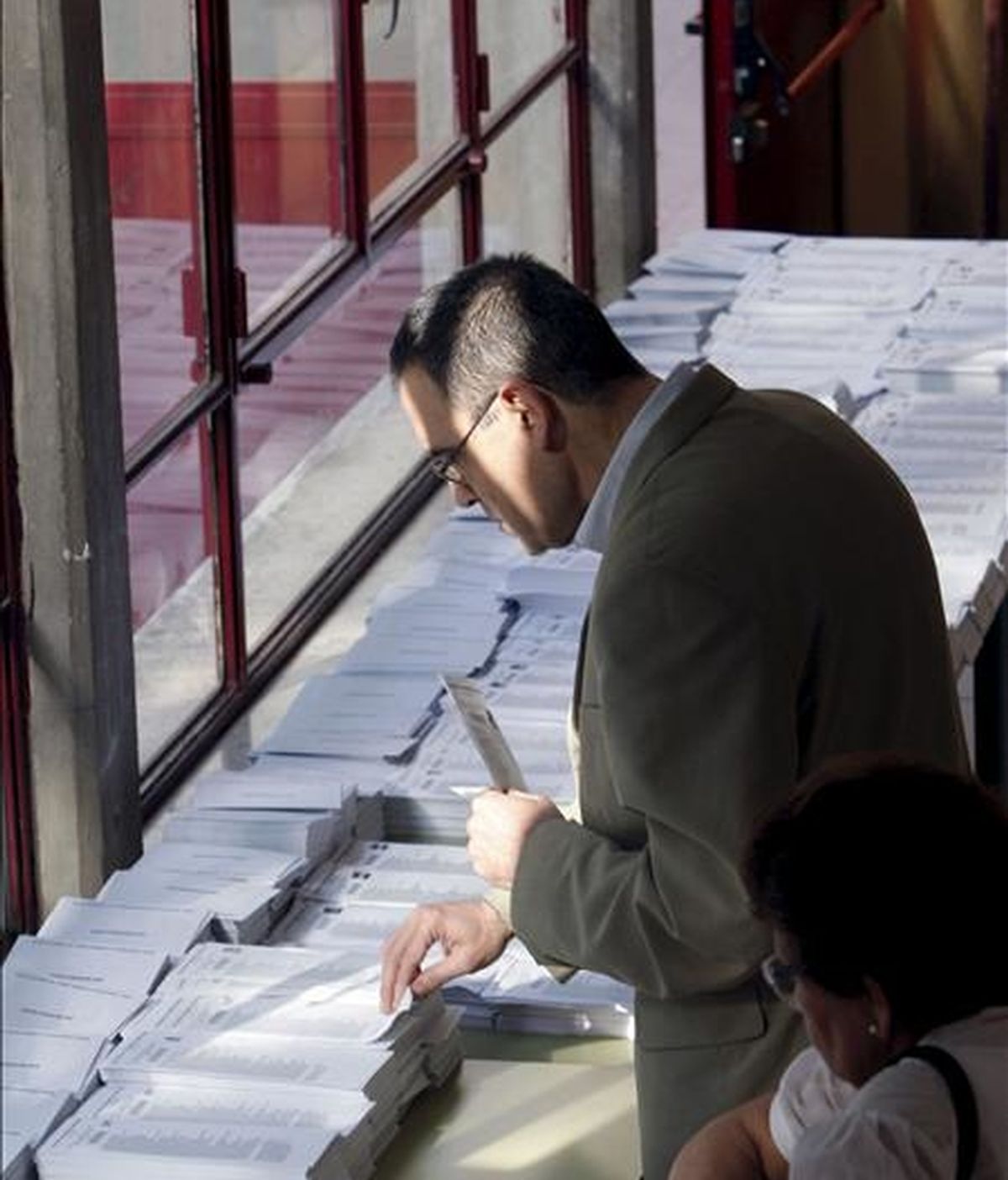 Un ciudadano elige las papeletas antes de ejercer su derecho al voto enlas elecciones al Parlamento Europeo, en el colegio Bernardette de Madrid. EFE/Archivo