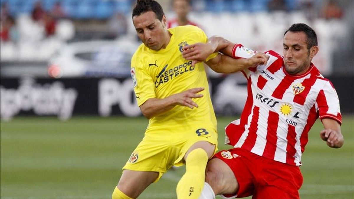 El centrocampista del Almeria Juanma Ortiz (d), pelea un balón con el centrocampista del Villarreal, Santi Cazorla, durante el encuentro correspondiente a la trigésimo sexta jornada de primera división en el Estadio de los Juegos Mediterraneos de Almeria. EFE