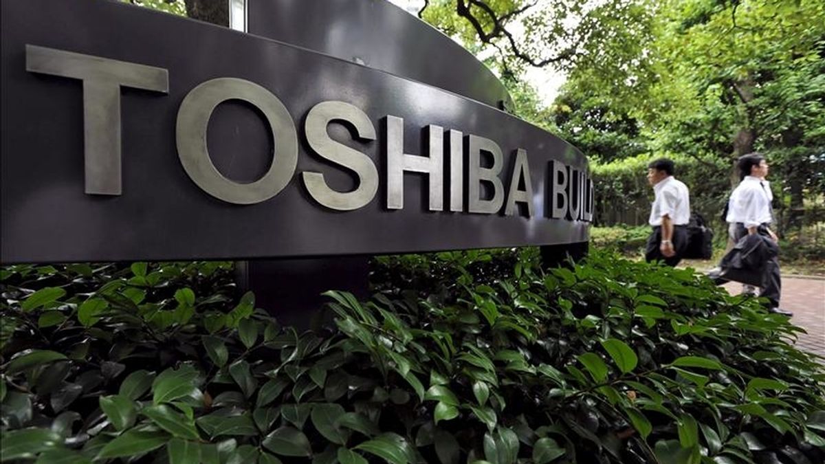 Dos hombres caminan frente a la sede de la empresa japonesa de electrónica Toshiba en Tokio, Japón. EFE/Archivo