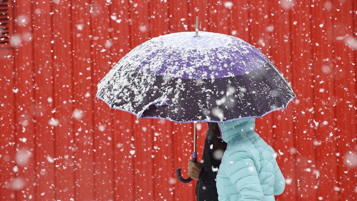 Varias personas caminan por una calle en la localidad cántabra de Reinosa, comunidad se encuentra en alerta por nevadas