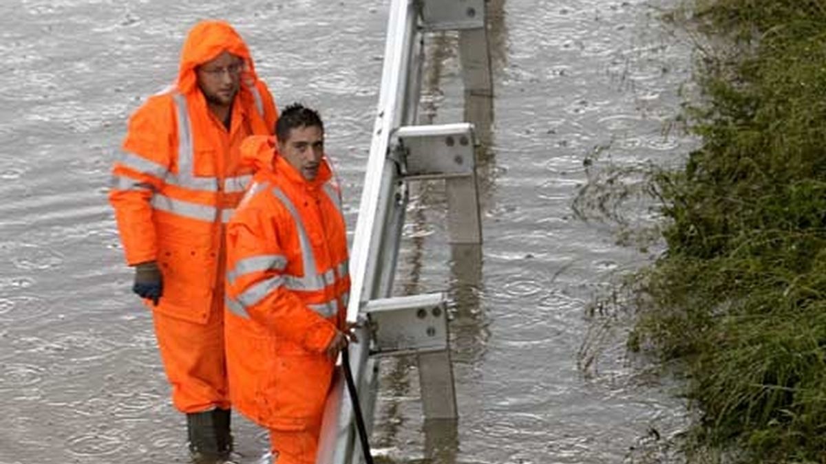 Dos operarios de la Diputación de Vizcaya intentan aliviar de agua en la carretera N-637, a su paso por la localidad vizcaína de Berango. Foto: EFE Dos operarios de la Diputación de Vizcaya intentan aliviar de agua en la carretera N-637, a su paso por la localidad vizcaína de Berango. Foto: EFE