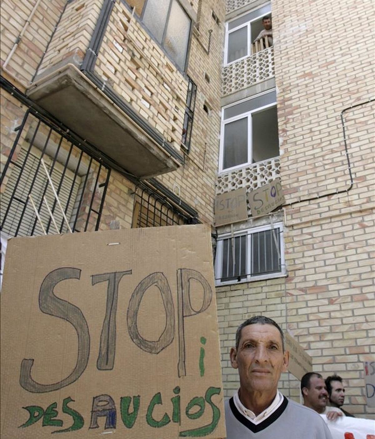 Vecinos y miembros de la Plataforma de Afectados por las Hipotecas de El Palmar ante la vivienda de Rabah Maizi, el joven de 32 años que lleva diez en España, donde vino procedente de Marruecos en busca de trabajo, en el barrio de Los Rosales de Murcia, donde han impedido el desalojo de Maizi y su familia. EFE