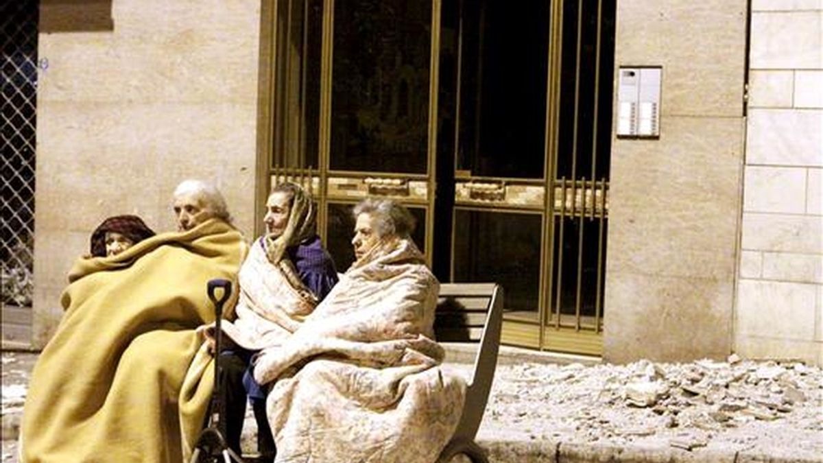 Cuatro ancianas sentadas en el banco de una calle junto a los escombros provocados por el terremoto de hoy de 5,8 grados de magnitud en la escala de Richter que sacudió el centro de Italia durante la madrugada, en L'Aquila. EFE