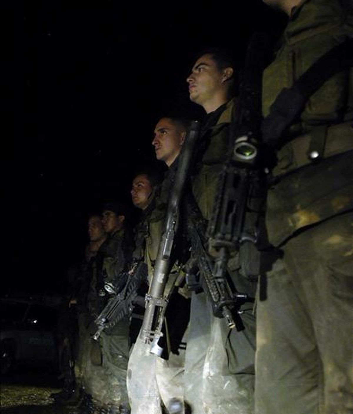 Integrantes de la Policía Nacional esperan la llegada de siete de sus compañeros muertos en combates en el departamento del Cauca, al suroeste del país. EFE