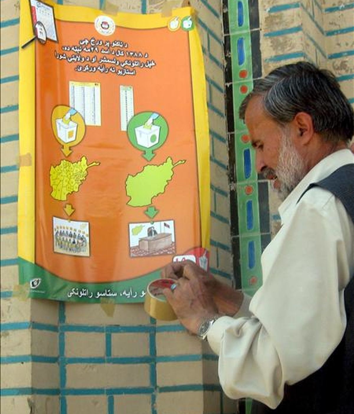 Un hombre coloca un cartel electoral en una pared en Kandahar, sur de Afganistán, hoy martes 16 de junio. Afganistán celebrará elecciones presidenciales el próximo 20 de agosto. EFE