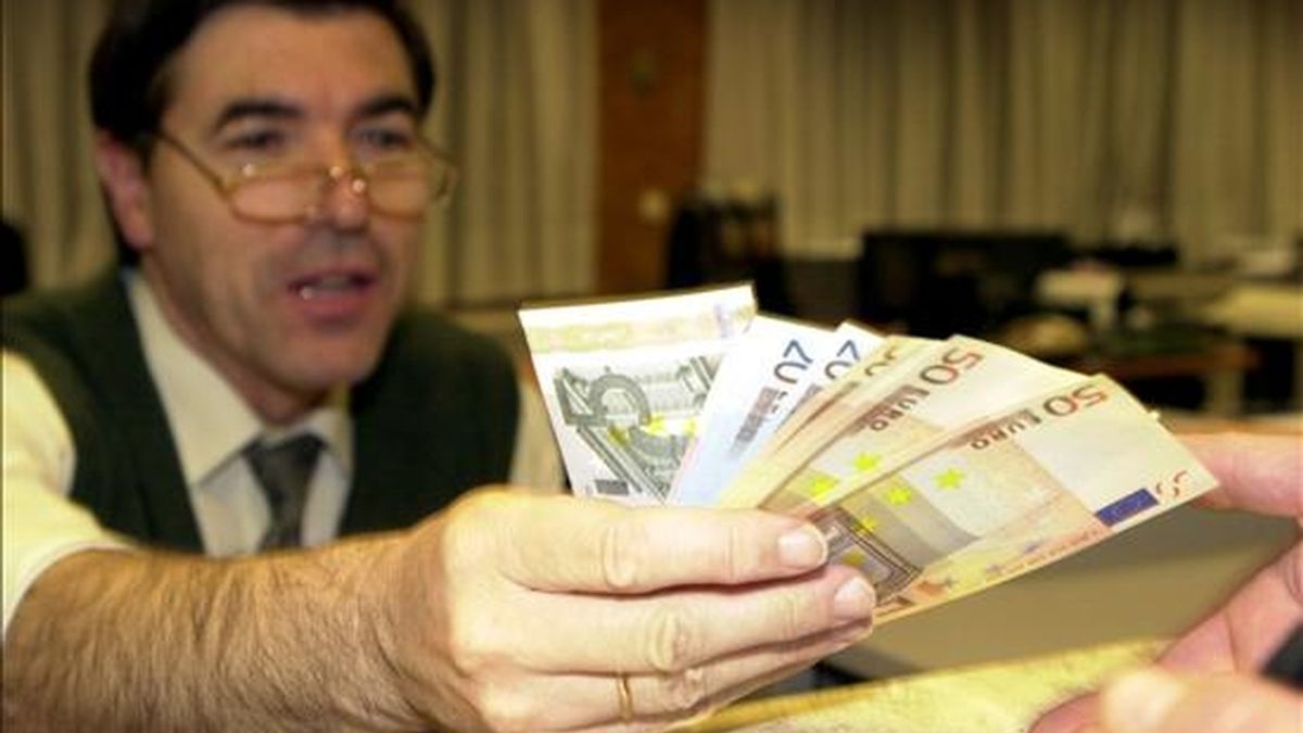 Un empleado de banca muestra billetes de euro. EFE/Archivo