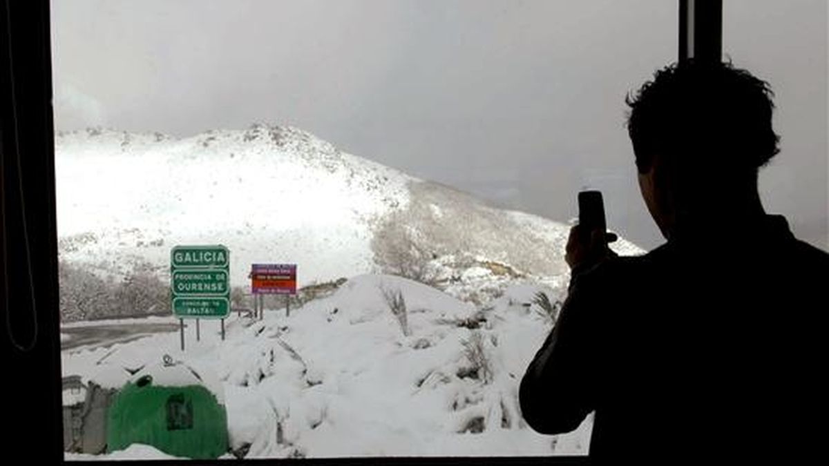 Un joven fotografía el paisaje de nieve desde el interior de un restaurante situado en la frontera entre Baltar (Ourense) y Montealegre (Portugal), a pocos metros del cartel que anuncia la entrada en Galicia. EFE