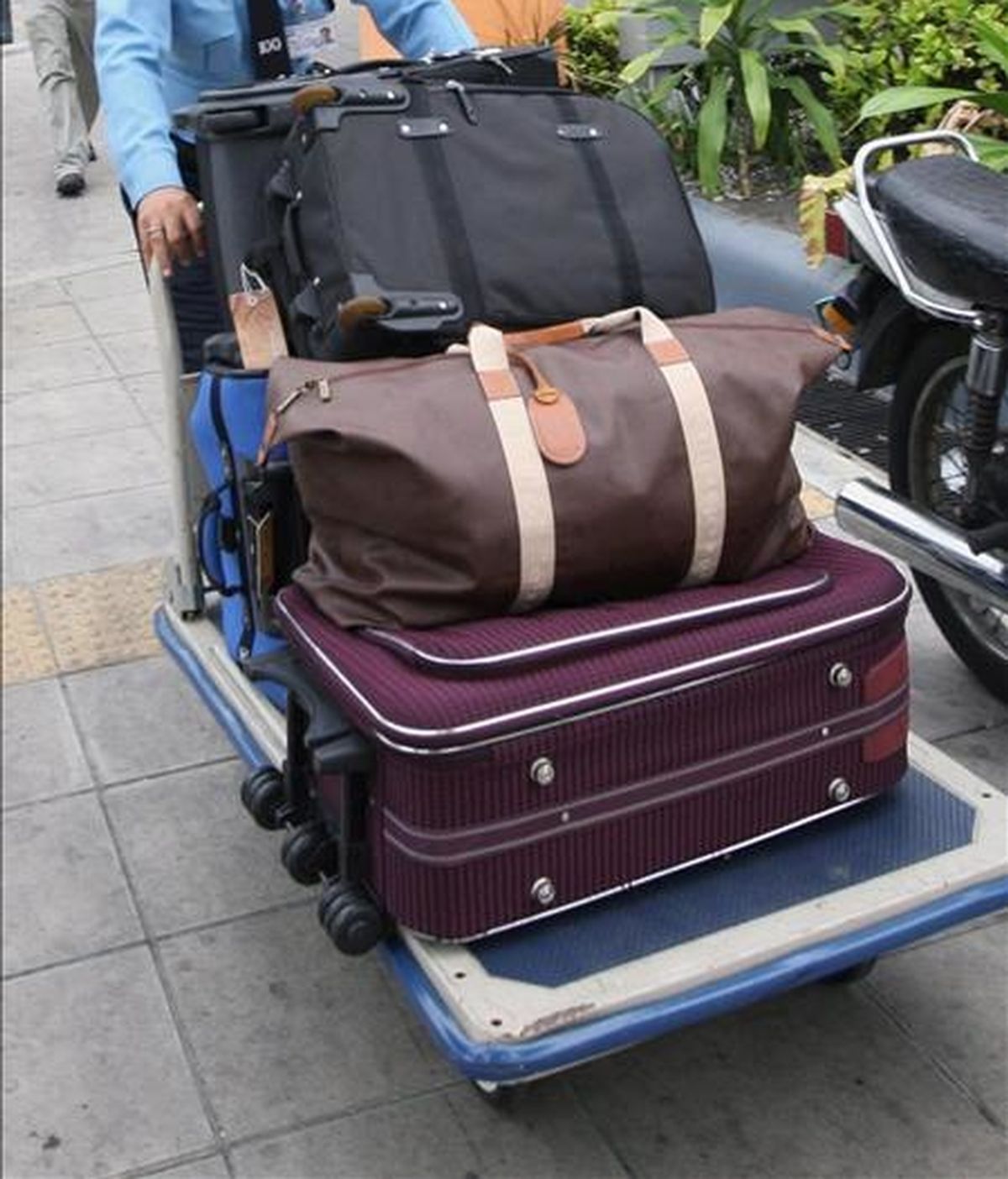 Un empleado de un hotel empuja un carrito lleno de maletas. EFE/Archivo