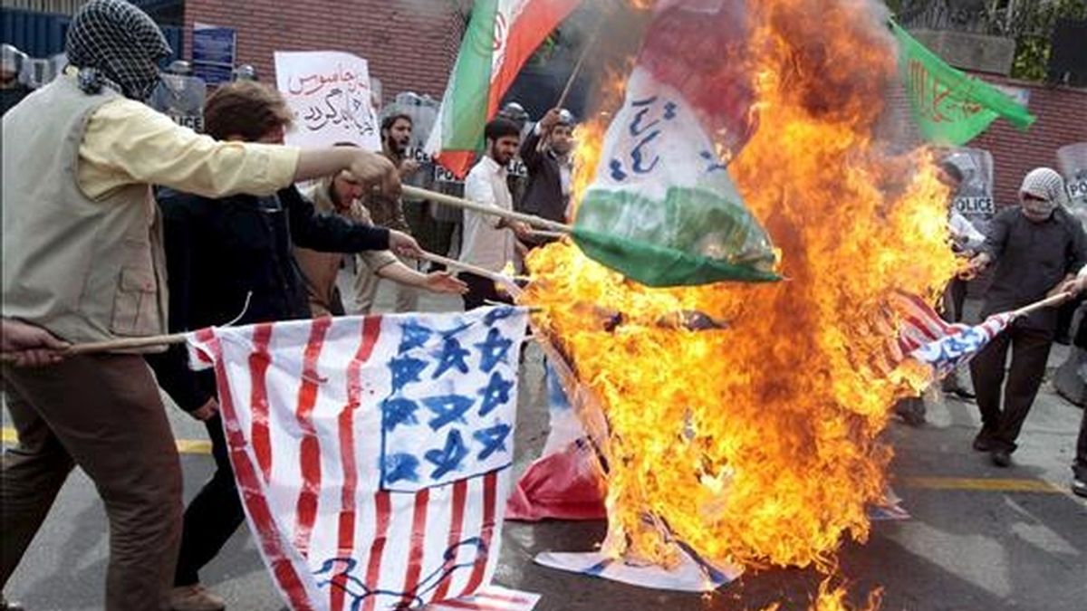 Seguidores del presidente iraní Mahmud Ahmadineyad queman banderas durante una concentración en el exterior de la embajada británica en Teherán, Irán, ayer martes 23 de junio. EFE/ Archivo