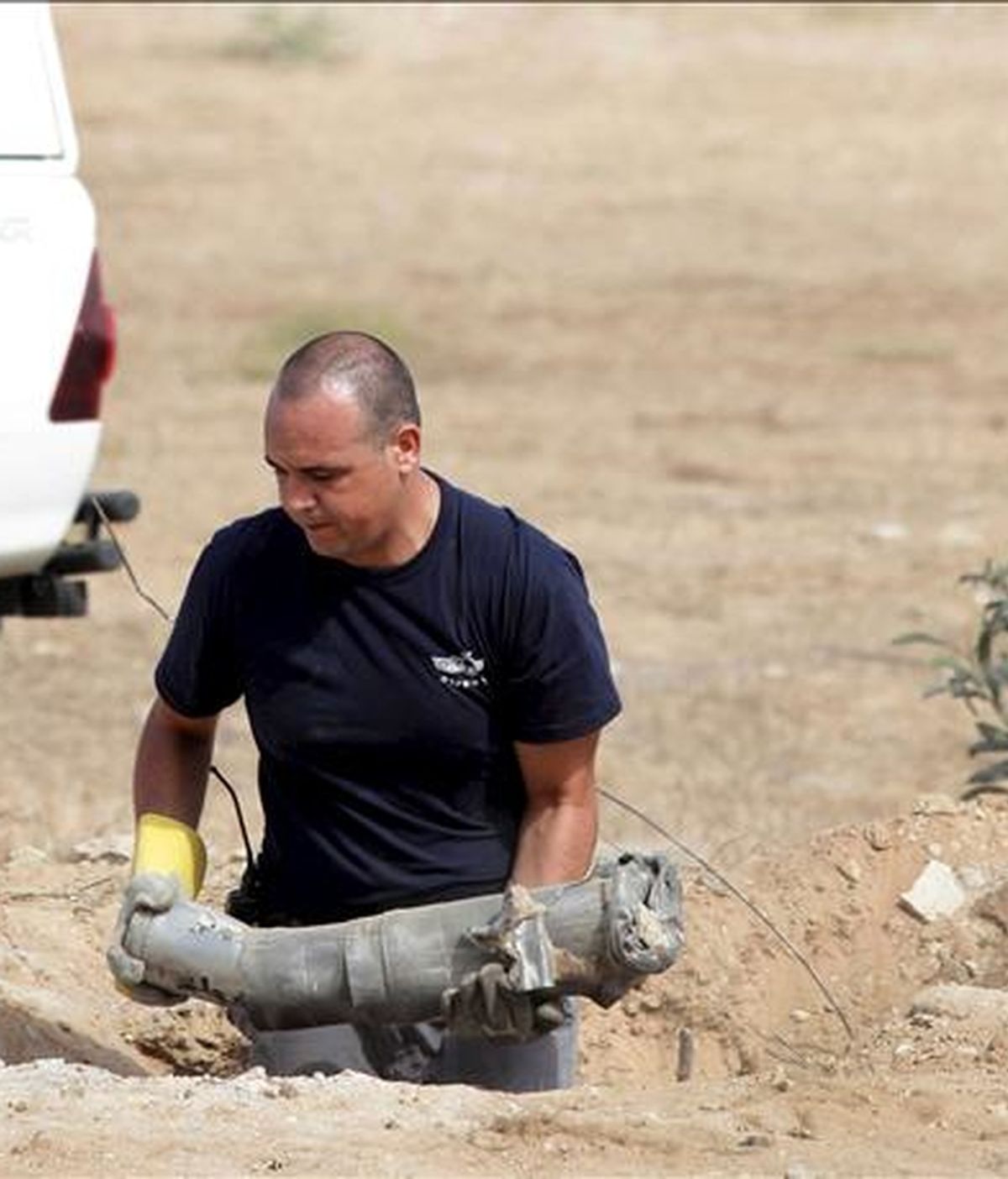 Un zapador de la policía israelí remueve los restos de un cohete del tipo Katyusha que impactó hoy, en una zona residencial de la ciudad israelí de Ashkelón, situada a unos diez kilómetros del norte de la franja de Gaza, sin causar víctimas aunque sí daños materiales, según informan los medios locales. EFE