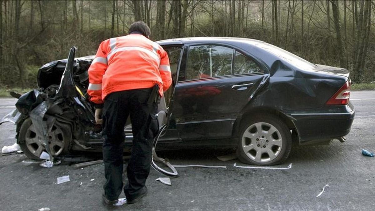 Un agente de la Ertzaintza inspecciona un coche tras un accidente de tráfico en el que fallecieron dos peronas a la altura del kilómetro 87 de la carretera nacional 634. EFE/Archivo